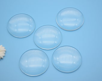 May include: Five clear round glass or plastic domes on a light blue background.