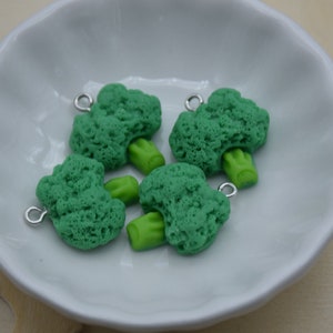 Puede incluir: Cuatro encantos de brócoli verdes con anillos de salto plateados. Los encantos están hechos de arcilla polimérica y tienen una textura realista.