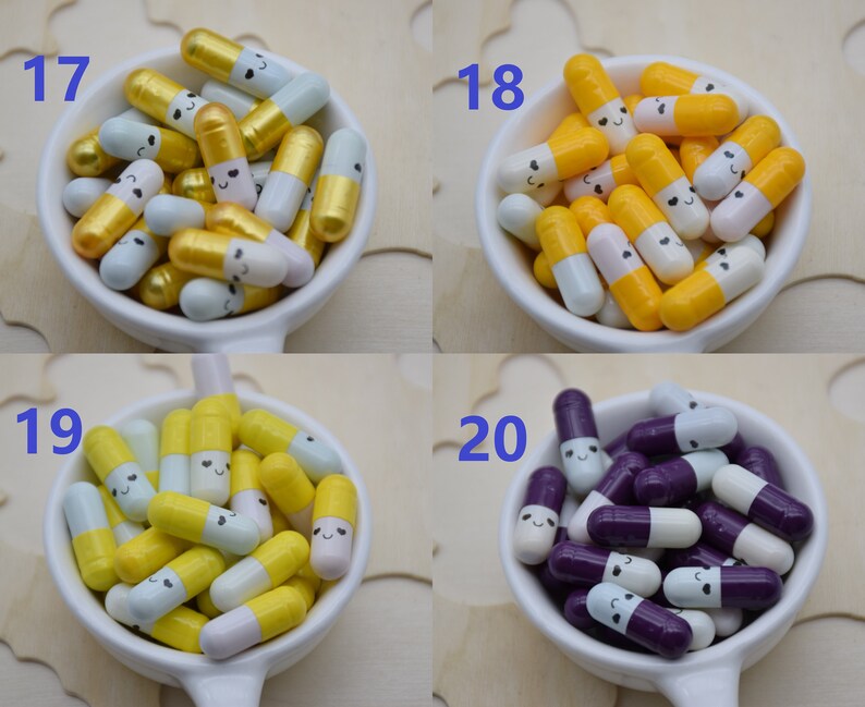 Puede incluir: Una colecci&oacute;n de cuentas coloridas en forma de c&aacute;psula sonriente en peque&ntilde;os cuencos blancos. Las cuentas est&aacute;n en varias combinaciones de colores, incluyendo oro y blanco, amarillo y blanco, y morado y blanco. Los n&uacute;meros 17, 18, 19 y 20 son visibles.