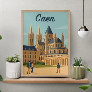Può includere: Una stampa artistica incorniciata con un'illustrazione stilizzata di Caen, Francia, con un cielo azzurro e un edificio color beige. La parola "Caen" è scritta in alto. La stampa è esposta su una mensola di legno con piante.