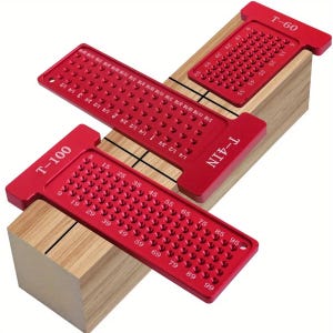 May include: Three red aluminum woodworking layout tools, labeled T-100, T-4IN, and T-60, are arranged on a wooden block. Each tool has a series of holes and measurement markings in inches. The tools are designed for precise measurements and layout tasks.