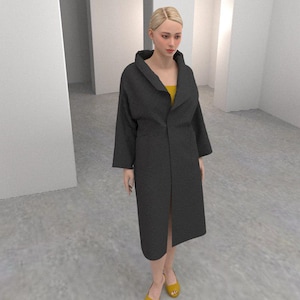 May include: A dark grey coat with a wide collar and long sleeves. The coat is worn over a yellow top and paired with yellow flats. The setting is a minimalist, white-walled space with arched doorways.
