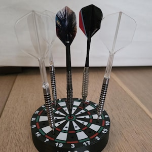 May include: A black and green dart holder with a bullseye design, holding five darts. The darts have various colored flights and silver shafts. The name "mike" is printed in white on the holder.