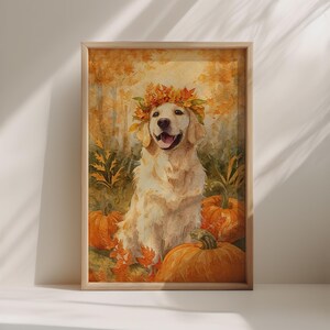 Puede incluir: Pintura a la acuarela de un Golden Retriever con una corona de hojas de otoño, rodeado de calabazas y follaje otoñal. La obra de arte está enmarcada en un marco de madera clara, evocando un tema cálido y estacional.