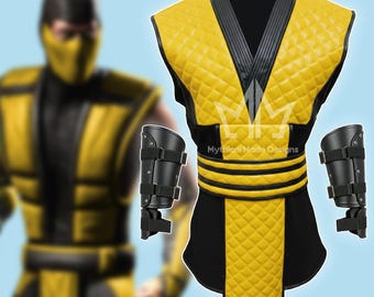 Puede incluir: Un disfraz amarillo y negro con acolchado en forma de diamante, un cuello negro y protectores de brazos a juego. El disfraz tiene un cinturón negro con rayas amarillas. El texto "Mythical Made Designs" es visible en el disfraz.