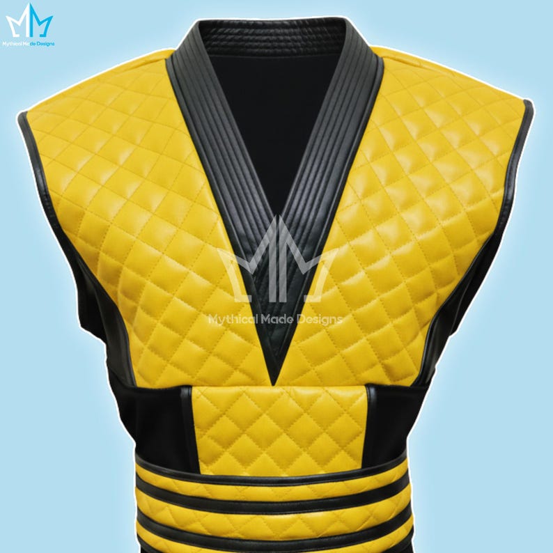 May include: A yellow quilted vest with black trim and accents. The vest features a diamond pattern and a V-neck design. The text "Mythical Made Designs" is visible on the vest.