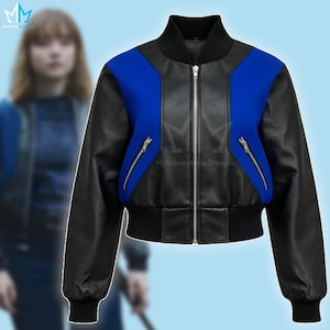Puede incluir: Chaqueta bomber negra y azul con cierre de cremallera. La chaqueta tiene mangas de cuero negro y un dobladillo y cuello acanalados negros. Los paneles frontales son azules. Tiene dos bolsillos con cremallera. La marca "Mythical Made Designs" es visible.