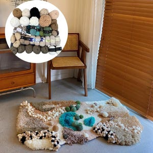 以下が含まれることがあります： 様々な色と質感を持つユニークなデザインの手作りのラグ。ベージュ、茶色、青色の要素があり、毛糸玉のコレクションも含まれています。ラグはコンクリートの床に置かれています。