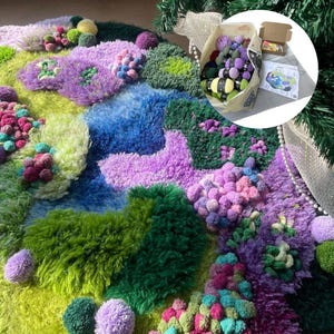 Peut inclure: Un tapis textur&eacute; et color&eacute; avec des formes et des couleurs vari&eacute;es, notamment du vert, du bleu, du violet et du rose. Le tapis pr&eacute;sente un design en relief avec des accents de pompons. Un sac de laine et une petite bo&icirc;te sont en arri&egrave;re-plan.