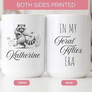 May include: White 15 oz ceramic mug with a raccoon illustration and the name "Katherine" on the front. The back of the mug reads "IN MY Feral Fifties ERA". The mug is printed on both sides.
