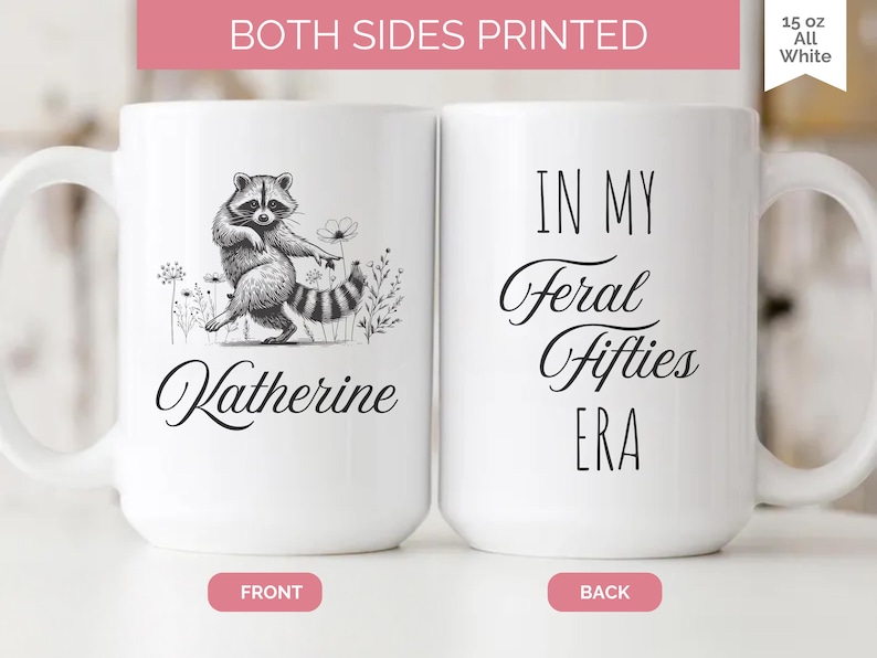 May include: White 15 oz ceramic mug with a raccoon illustration and the name "Katherine" on the front. The back of the mug reads "IN MY Feral Fifties ERA". The mug is printed on both sides.