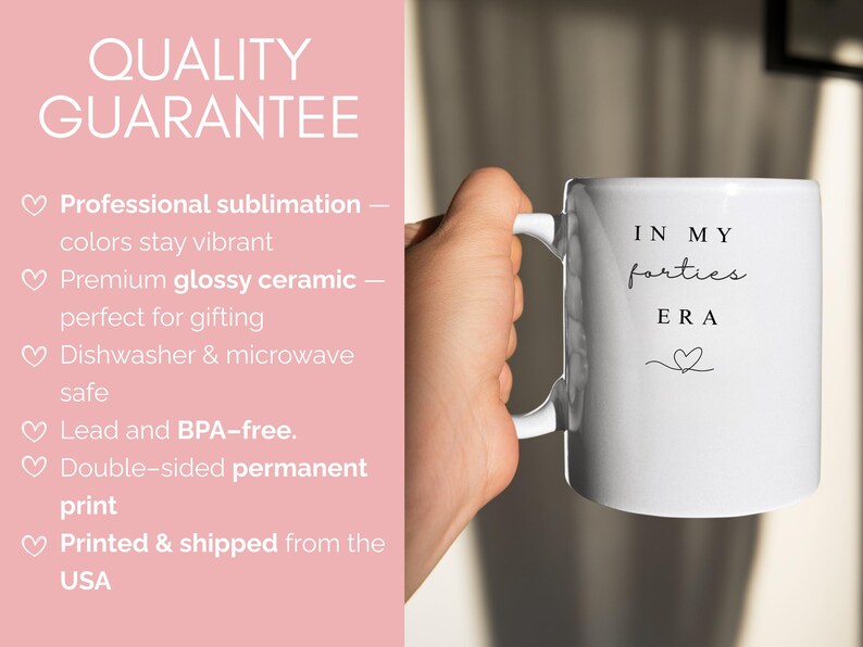 May include: White ceramic mug with the text "IN MY forties ERA" in black script and a heart symbol. The mug has a white handle and is held by a person. The image also includes text about the product's quality.