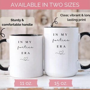 May include: Two white ceramic mugs with black handles and rims. The mugs have the text "IN MY forties ERA" and a heart symbol. One mug is 11 oz, the other is 15 oz. The image text says "Available in two sizes".