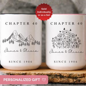May include: Two white ceramic mugs with black text and graphics. The left mug has a black handle, mountain illustration, and the text Chapter 40, James & Olivia, Since 1986. The right mug has a pink handle, floral illustration, and identical text.