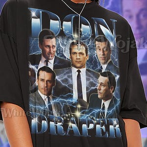 May include: Black unisex t-shirt featuring a graphic of the words "DON DRAPER" with images of men in suits and ties. The shirt has the word "SHIRT" and "Unisex" printed on it.