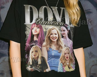 May include: Black unisex t-shirt featuring a graphic of Dove Cameron with the text "DOVE Cameron" in silver. The shirt also has the text "SHIRT Unisex" in white. The model is wearing a 2XL shirt.
