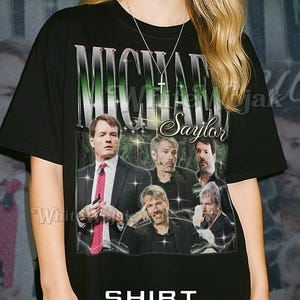 May include: Black unisex t-shirt with a graphic of Michael Saylor and the text "Michael Saylor". The shirt has a vintage design with a lightning bolt effect and the word "Shirt Unisex" at the bottom.