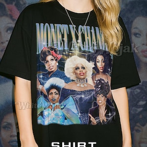 May include: Black unisex t-shirt featuring a graphic of several people with the text "MONET X CHANGE" and "SHIRT Unisex". The shirt has a vintage aesthetic and is made of a soft material.
