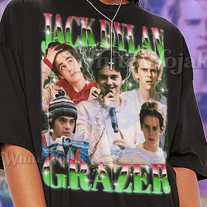 May include: Black unisex t-shirt featuring a graphic of a group of young men with the text "JACK DYLAN GRAZER" in green and white. The shirt also has the word "SHIRT" and "Unisex" in white.