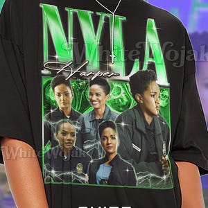 May include: Black unisex t-shirt featuring a green and white graphic design with the text "NYLA Harper" and images of women. The shirt also has the text "SHIRT Unisex".