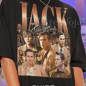 May include: Black unisex t-shirt featuring a graphic of five men with the text "JACK" in a copper color. The shirt also has the text "Shirt Unisex" in white. The first model is wearing a 2XL unisex shirt.