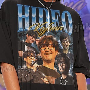 May include: Black unisex t-shirt featuring a graphic of Hideo Kojima with the text "HIDEO KOJIMA". The shirt has a vintage design with multiple images of Kojima. The shirt is described as oversized.