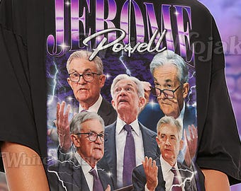 May include: Black unisex t-shirt featuring a graphic of Jerome Powell and the text "Jerome Powell" in a purple and white design. The shirt also has the text "Shirt Unisex".