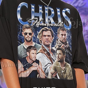 May include: Black unisex t-shirt featuring a graphic of Chris Hemsworth with the text "CHRIS Hemsworth" in a blue and silver design. The shirt also has the word "SHIRT Unisex" printed on it.