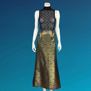 May include: A sleeveless black lace top and a floor-length gold skirt with a repeating black pattern are displayed on a mannequin. The skirt has a slight A-line shape. The mannequin is set against a blue background.