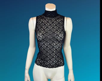 May include: Black sleeveless lace top with a mock neck. The intricate floral lace pattern covers the entire top. The top is displayed on a mannequin against a blue background.