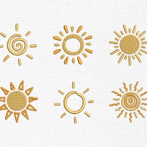 Puede incluir: Seis diseños de sol bordados en tonos dorados. Cada sol tiene un estilo único, con variaciones en la forma y disposición de los rayos. Los soles están sobre un fondo blanco texturizado.