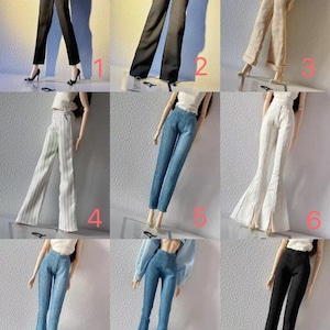 May include: A collection of doll-sized pants in various styles and colors. The pants include black, gray, beige, and blue denim options. Styles range from straight-leg to flared, with some featuring vertical stripes.