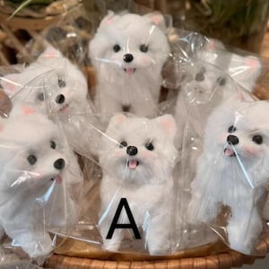 May include: A collection of white plush dog figurines, each individually wrapped in clear plastic. The dogs have black eyes, pink ears, and open mouths with pink tongues. They are arranged in a woven basket.