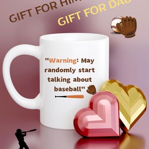 May include: A white ceramic mug with the text "Warning: May randomly start talking about baseball." The mug features a baseball bat and glove graphic. Two heart-shaped decorations and the words "GIFT FOR HIM" and "GIFT FOR DAD" are also visible.