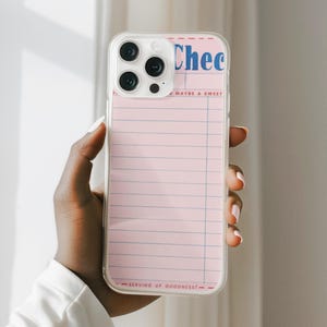 May include: Clear phone case with a pink lined paper design. The top of the design has the word "Chec" in blue, with the words "MAYBE A SWEET" below it. The bottom of the design has the words "SERVING UP GOODNESS!" in black.
