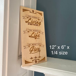 Op de afbeelding: Een houten bord met een citaat van Winston Churchill dat luidt: "Je verdient je brood met wat je verdient. Je maakt je leven met wat je geeft." Het bord is 12 inch bij 6 inch en is 1/4 formaat.
