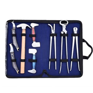 Peut inclure: Un ensemble de huit outils de maréchalerie en métal disposés dans une trousse de transport noire zippée avec une doublure intérieure bleue. La collection comprend deux couteaux à manche en bois foncé, un marteau à manche en bois et trois pinces.