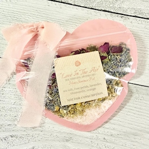 Puede incluir: Una taza de cerámica blanca con un asa negra y el texto "But First, Coffee" en negro y negrita. La taza está sobre una superficie blanca. La taza es probablemente para bebidas calientes.