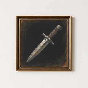 May include: A framed artwork featuring a dagger with a worn, metallic blade and a leather-wrapped handle. The dagger is set against a dark background within a gold-toned frame, creating a vintage aesthetic.