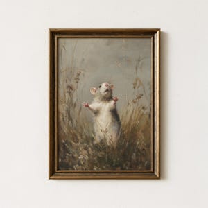 Puede incluir: Pintura enmarcada de estilo vintage de una rata blanca de pie en hierba alta con los brazos levantados. La obra de arte tiene una paleta de colores apagados y un marco dorado, evocando una estética clásica. La rata es el punto focal, sobre un fondo de tonos neutros.