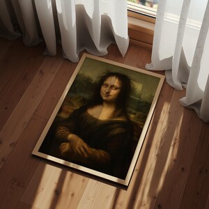May include: A framed rectangular print featuring a portrait of a person with long dark hair and a subtle smile, wearing a dark garment. The artwork is displayed in a light-colored wooden frame, showcasing a classic composition with muted tones.
