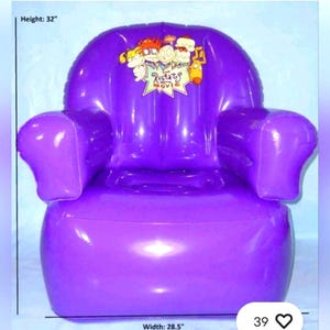May include: A purple inflatable chair with armrests. The chair features a Rugrats Movie graphic on the backrest. The chair is 81 cm high and 72 cm wide.
