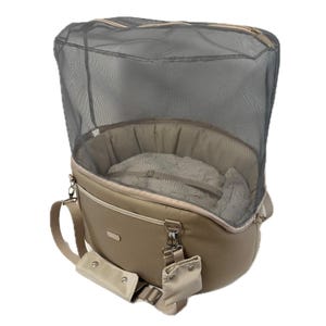 May include: Tan pet carrier with a mesh top and a soft, plush interior. The carrier has a shoulder strap and a small pouch attached. The mesh top is zippered for easy access and ventilation. The carrier is designed for small pets.