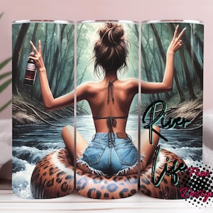 May include: A stainless steel tumbler featuring a woman relaxing on a leopard print float in a river, holding a bottle and making a peace sign. The tumbler has the words "River Life" in a script font.