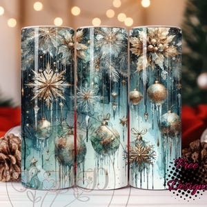 May include: Three cylindrical tumblers with a winter holiday theme. The design features gold and silver snowflakes, ornaments, and dripping icicles against a teal and white watercolor background. The tumblers have the text "Free Designs".