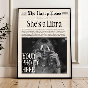 Könnte beinhalten: Schwarz gerahmter Zeitungsdruck mit der Überschrift "She's a Libra". Der Druck zeigt ein Schwarz-Weiß-Foto einer Frau, die Weingläser hält. Text enthält "The Happy Press" und "Your Photo Here."