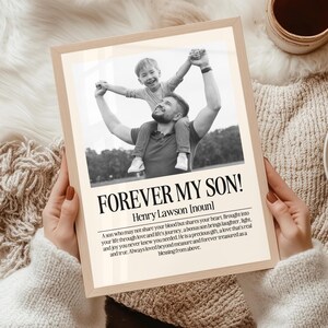 以下が含まれることがあります： 父と息子のモノクロ写真が額装されています。息子は父親の肩に座り、腕を上げています。フレームには「FOREVER MY SON！」というテキストと定義が記載されています。