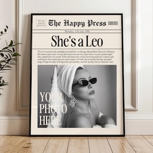 Peut inclure: Impression encadrée en noir et blanc avec le titre "She's a Leo" et le texte "The Happy Press". L'image présente une femme portant des lunettes de soleil et une serviette sur la tête. Les mots "Your Photo Here" sont également visibles.