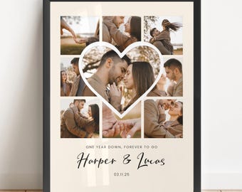 May include: Framed photo collage featuring a heart-shaped cutout with multiple images of a couple. The collage includes the text "ONE YEAR DOWN, FOREVER TO GO" and the names "Harper & Lucas" with a date below. The frame is black.
