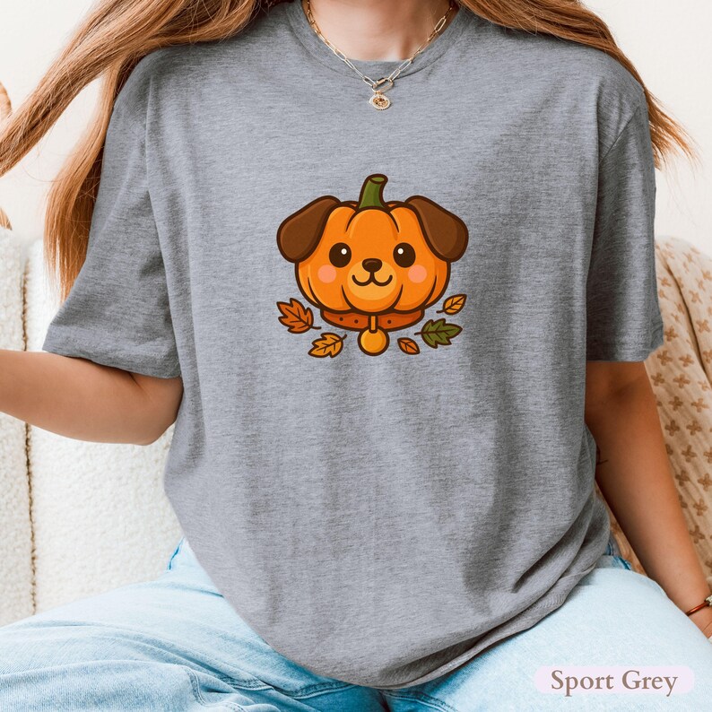 May include: Sport Grey t-shirt with a cartoon dog design. The dog has a pumpkin head, brown ears, and a collar, with autumn leaves around it. The text "Sport Grey" is at the bottom right of the shirt.